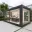Foto Schwarz gerahmter, voll verglaster Pop-up Store Container mit Naturkosmetik-Präsentation, Counter, Beleuchtung und Marken-Logo im Innenraum auf einer Außenfläche.
