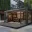 Foto Moderner, schwarzer Pop-Up Store in Container-Bauweise mit groĂźen Glasfronten, Holzterrasse und hochwertiger Innenbeleuchtung fĂĽr Retail-Zwecke in einem urbanen Umfeld.