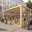 Foto Moderner, modularer Holz-Pavillon aus Fichtenholz mit großflächiger Verglasung, eingerichtet als Textil- und Lifestyle-Pop-up-Store auf einem belebten Stadtplatz.